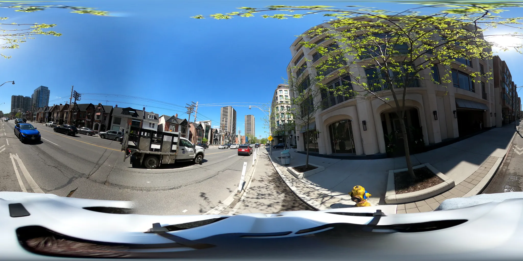Image of a streetscape taken with a 360 camera. The image is very distorted around the edges and has a pronounced fisheye effect