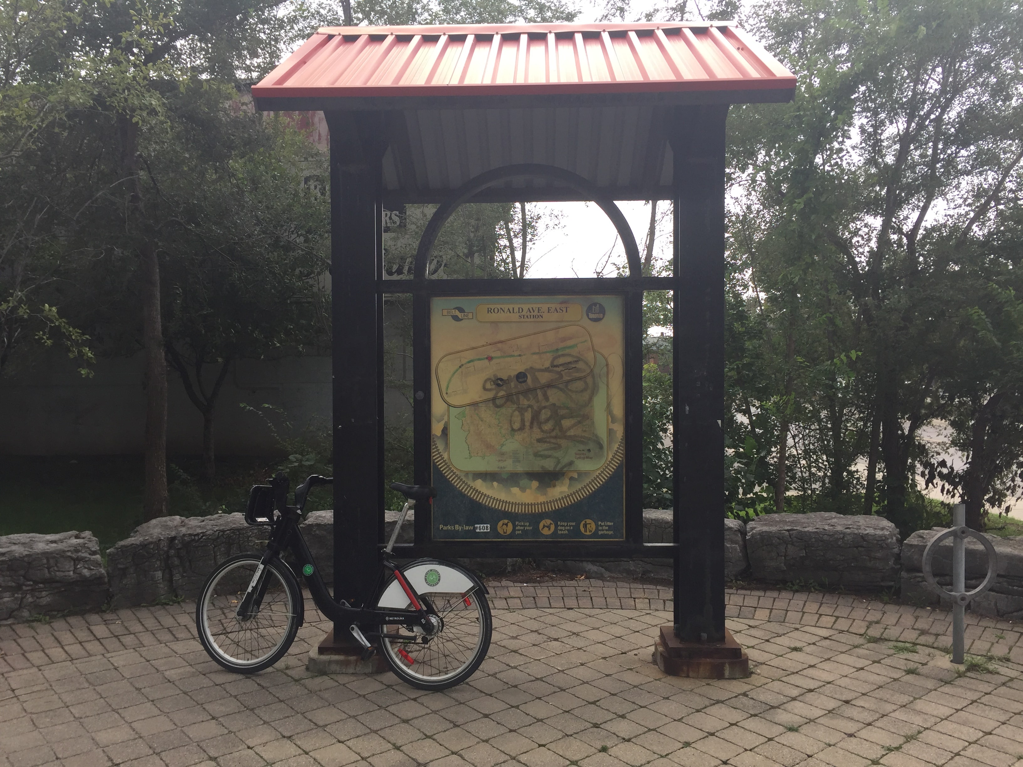 A Bikeshare Bike next to a sign titled Ronald Avenue Station